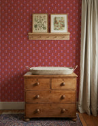 Bloemen Rood – Atelier Chien: wallpaper behind a wooden changing table with a changing basket.