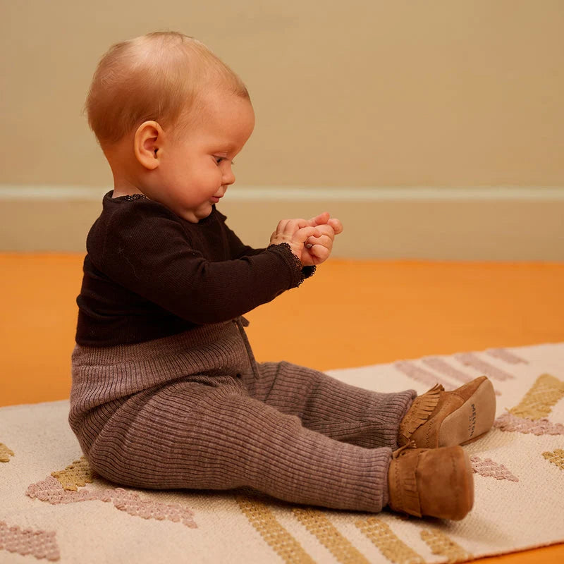 Moccasin Suede Slippers – Leather baby booties with suede non-slip sole – MELTON: child sitting while wearing the baby booties.