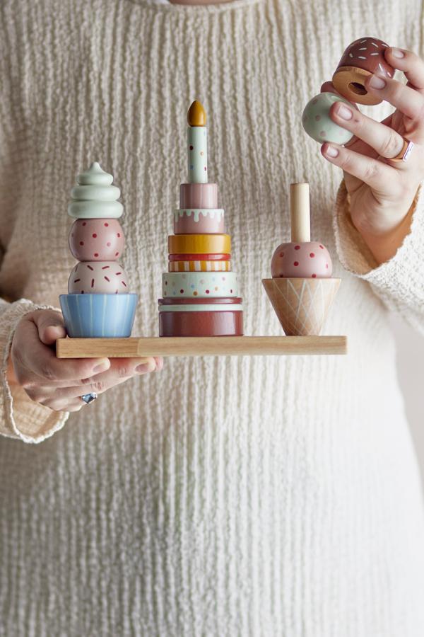 Celebrate Activity Toy – Bloomingville MINI: detail van een hand die een onderdeel op een stapel zet.