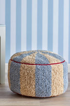 Charoline Pouf Multi – Bloomingville MINI: pouf in front of a wall with blue striped wallpaper.