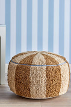 Charoline Pouf Brown – Bloomingville MINI: pouf in front of a wall with blue striped wallpaper.