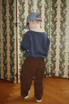 Wollen polo Basi – Dark Blue Stripe – Konges Sløjd: kind met blauwe polo en bruine broek, van achteren.
